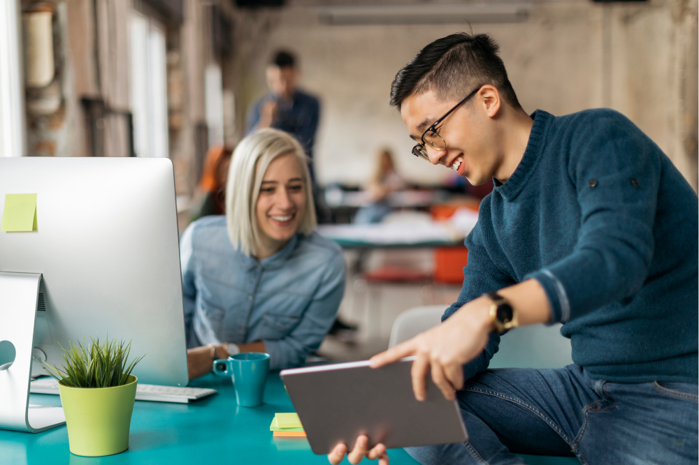 Two employees smiling, in a positive work environment.