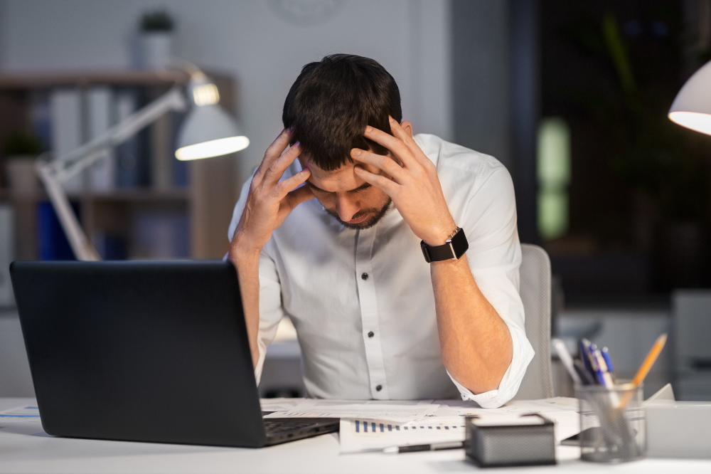 Male employee experiencing work related stress.